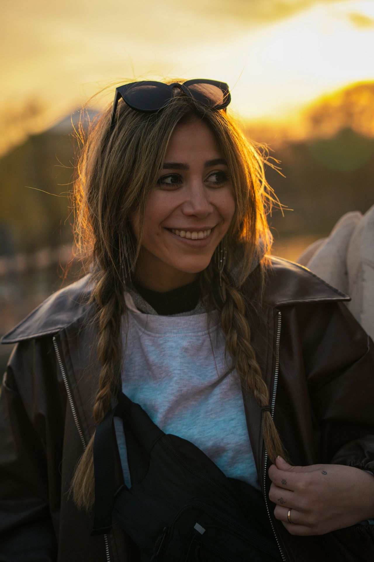 Smiling woman poses in front of a sunset.
